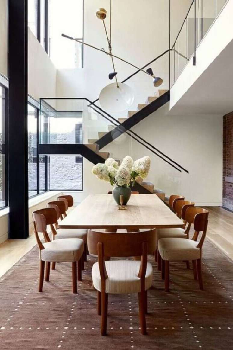 17. Cadeira de jantar de madeira para sala grande decorada com lumin&aacute;ria moderna &ndash; Foto: Elle Decor