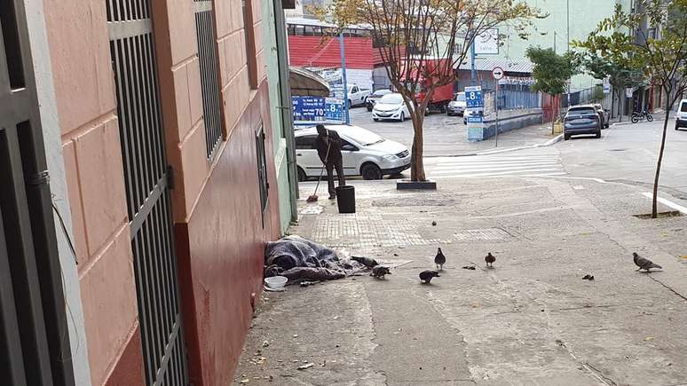 Homem dormindo em calçada na rua Tabatinguera, no centro de São Paulo