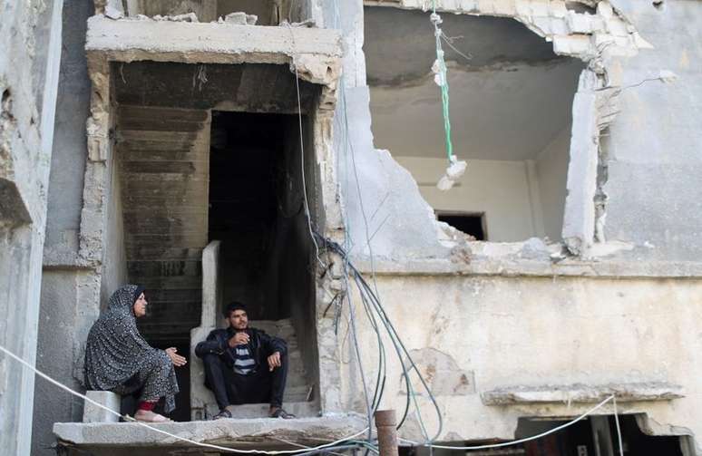 Palestinos em escombros de casa destru&iacute;da por ataque a&eacute;reo israelense em Gaza
09/06/2021
REUTERS/Mohammed Salem