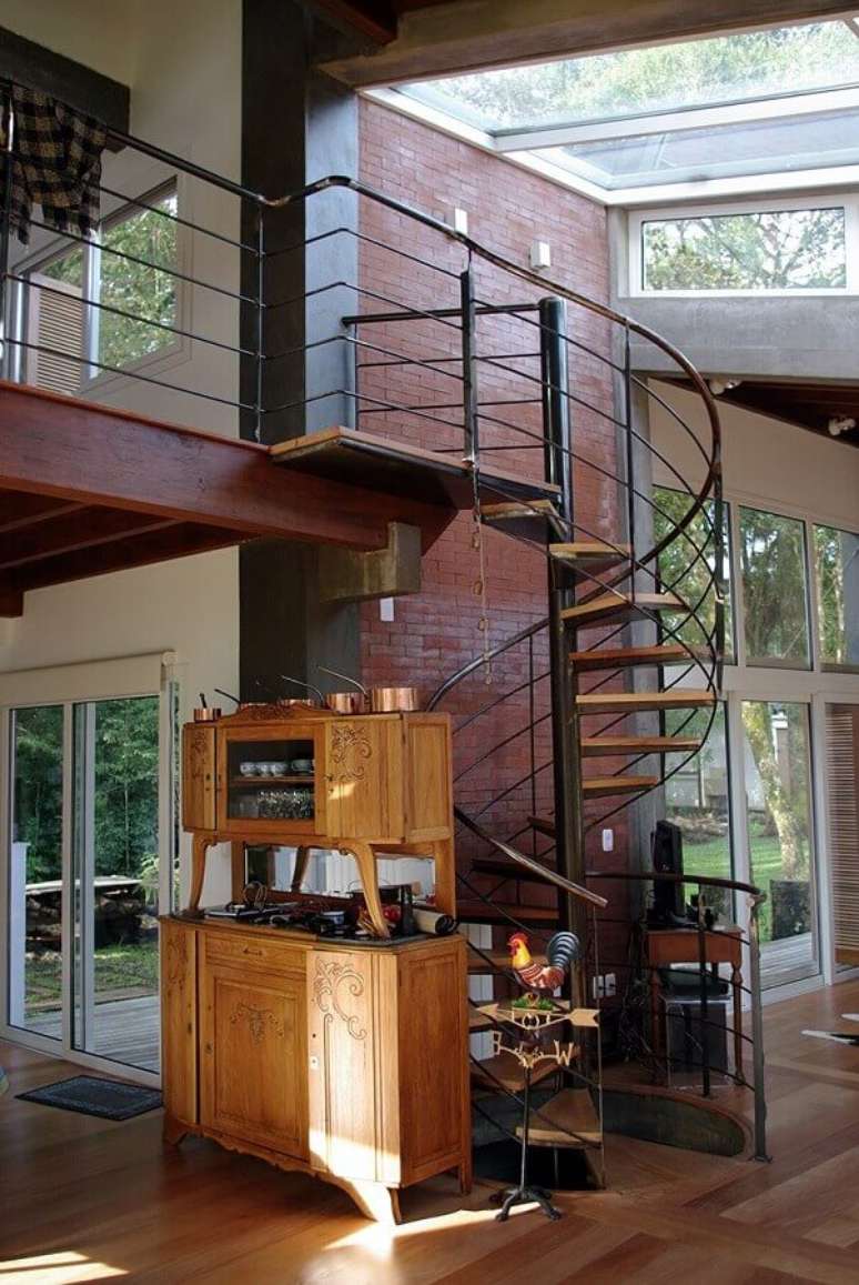 56. Modelo simples de escada espiral de madeira e ferro para casa decorada com parede tijolinho – Foto: Casa de Valentina