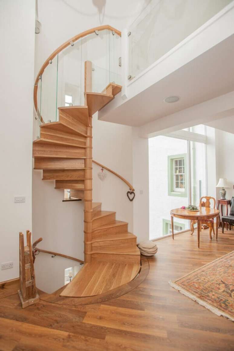 5. Decoração clean para casa branca com escada espiral de madeira – Foto: Homify