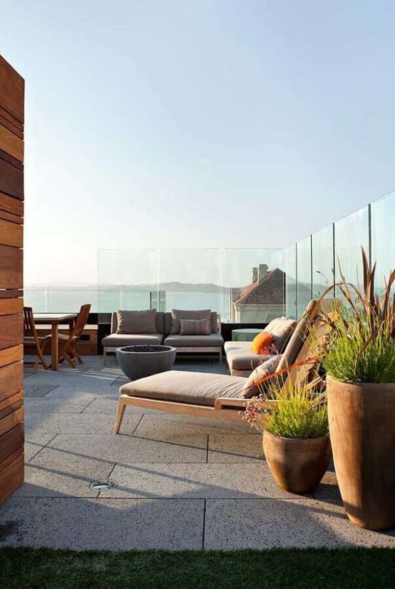 53. Terraço decorado com cadeira espreguiçadeira de madeira – Foto: Arquitetura e Engenharia