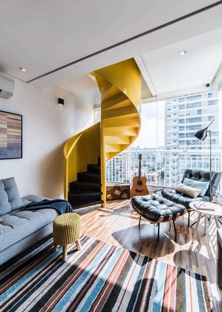 29. Decoração de sala com tapete listrado e escada espiral amarela moderna – Foto: Dicas Decor