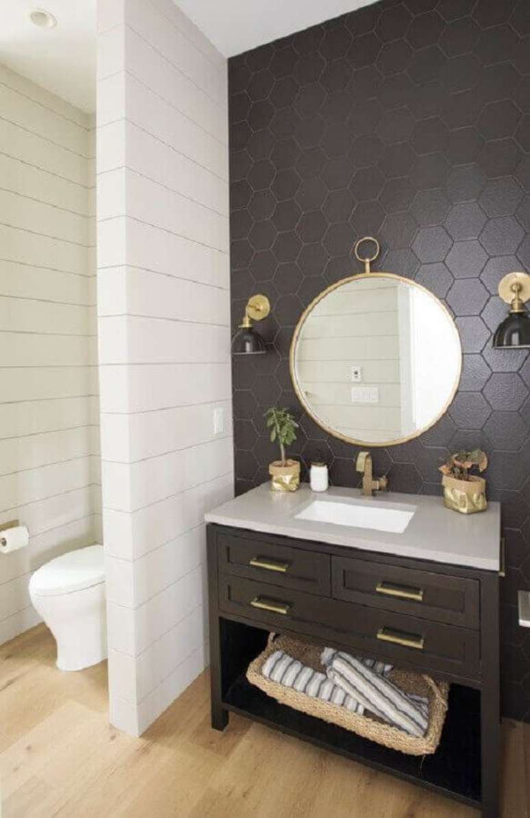 55. O revestimento cerâmico hexagonal preto combinado aos elementos em dourado traz sofisticação para o banheiro. Fonte: Apartment Therapy