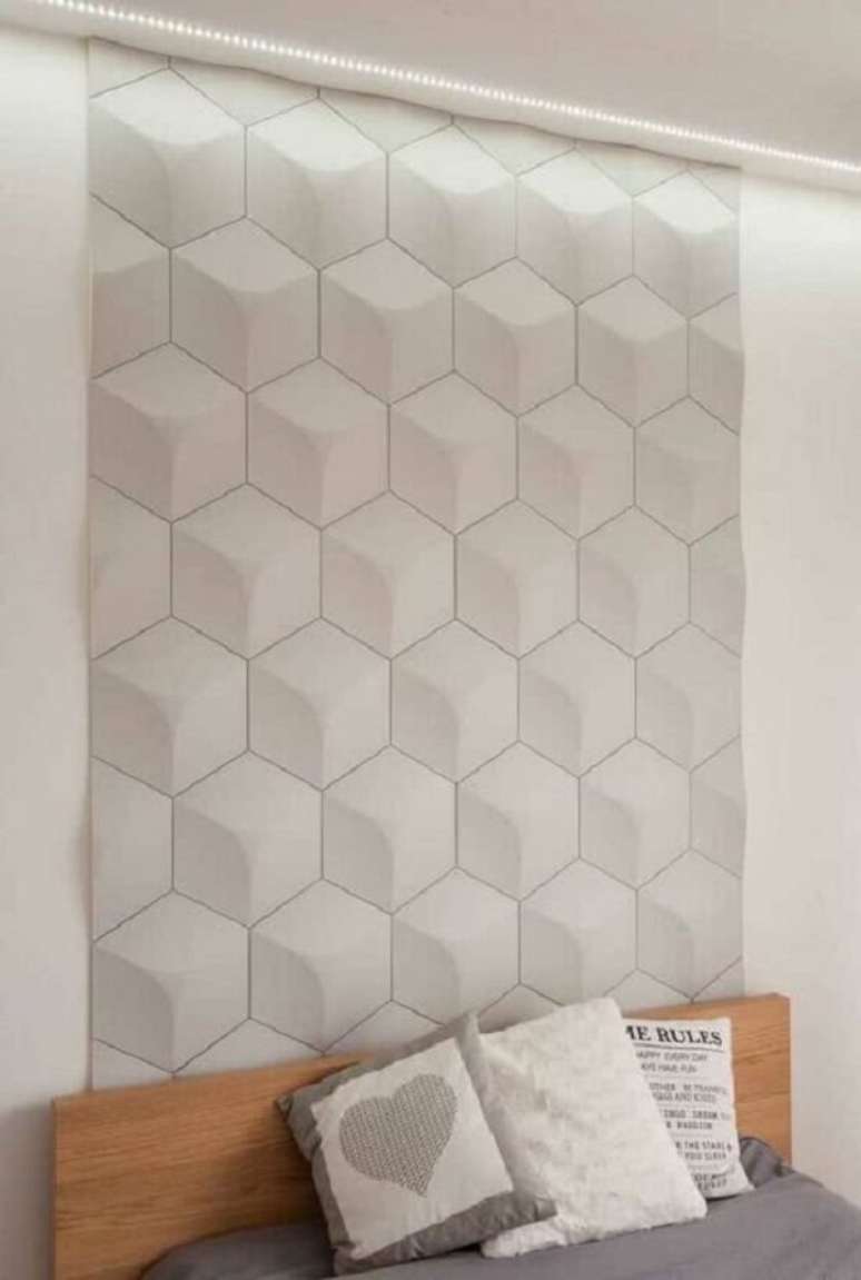 42. O revestimento cer&acirc;mico 3D branco se estende da cabeceira da cama at&eacute; o teto. Fonte: Pinterest