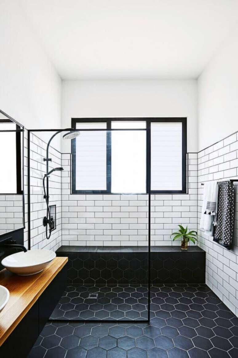 18. Banheiro minimalista com piso preto hexagonal e revestimento cer&acirc;mico branco. Fonte: Pinterest