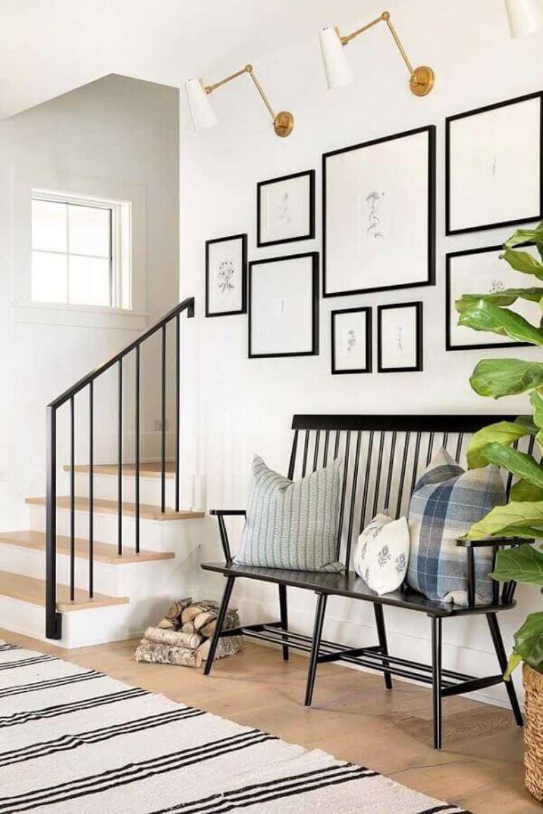 22. Decoração minimalista com cadeira namoradeira preta e vários quadros com moldura preta – Foto: Rangel Design de Interiores