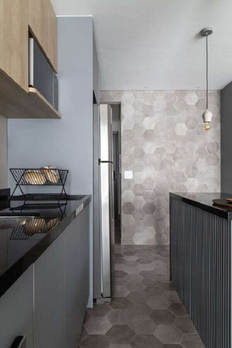 29. Cozinha moderna com revestimento cerâmico cinza que se estende do piso para a parede. Fonte: MSAC Arquitetura
