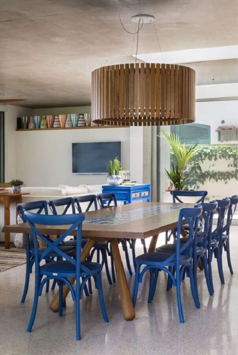 37. Decoração de sala de jantar com lustre de madeira e cadeira azul – Foto: Marina Linhares Interiores