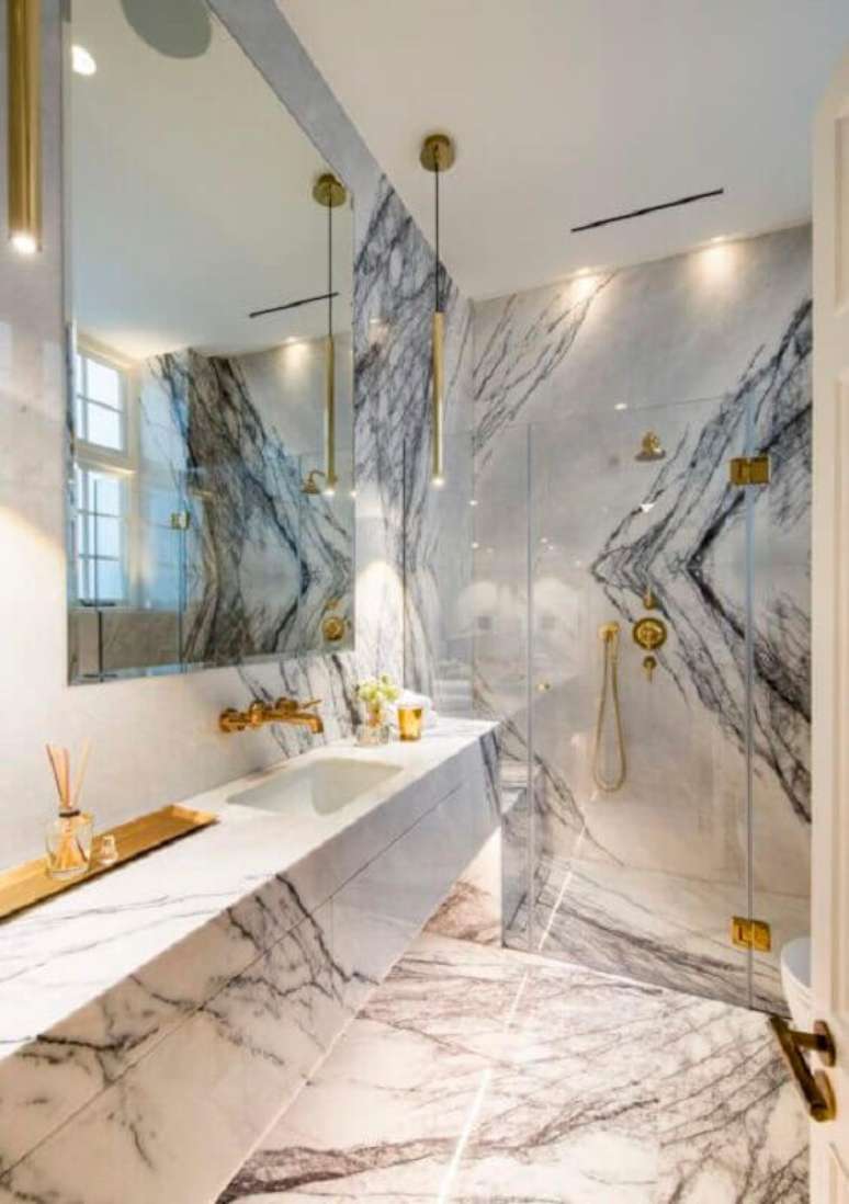 72. Pedra para bancada de mármore para banheiro sofisticado decorado com detalhes em dourado – Foto One Kindesign