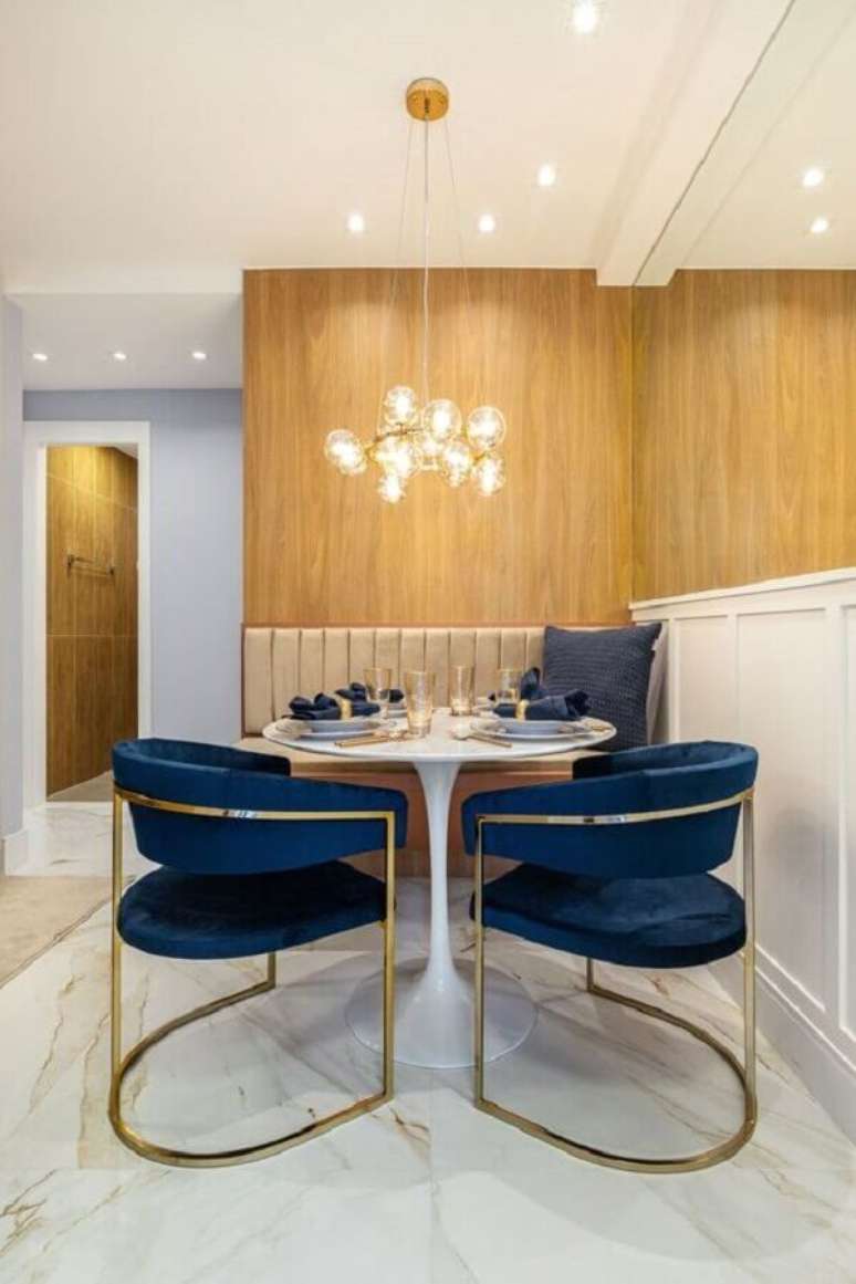 9. Cadeira azul marinho para sala de jantar moderna decorada com mesa redonda e parede de madeira – Foto: Etsy