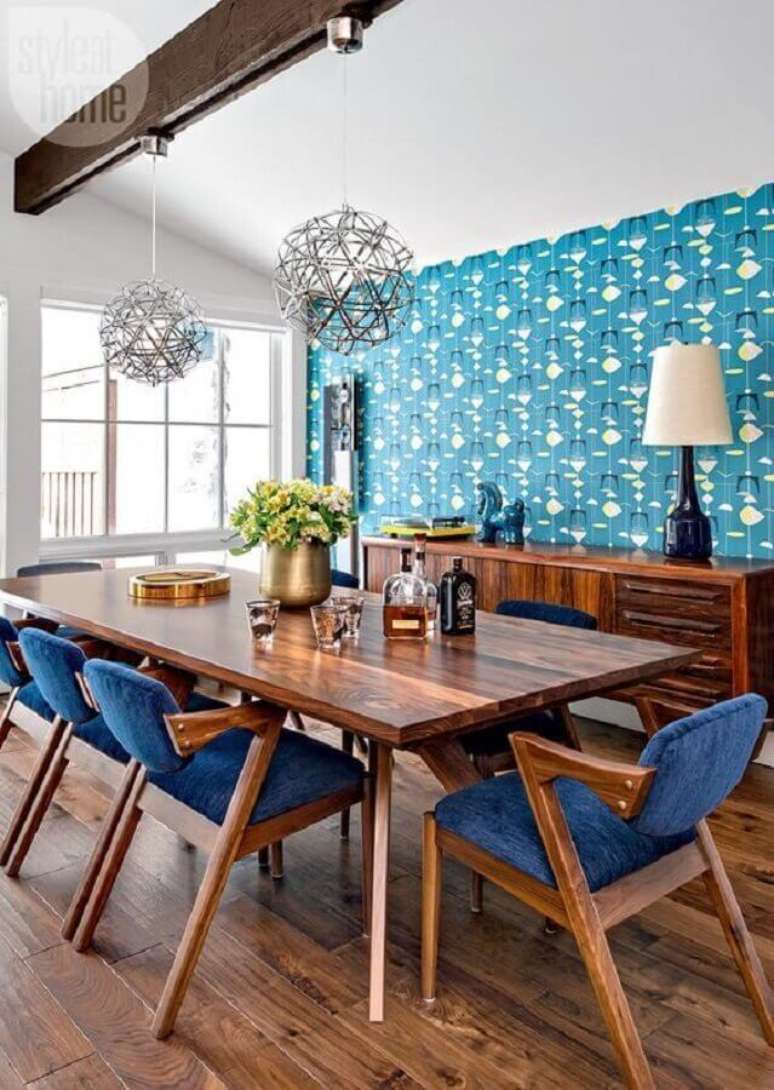 53. Papel de parede e cadeira estofada azul para decoração de sala de jantar com móveis de madeira – Foto: Curated Interior