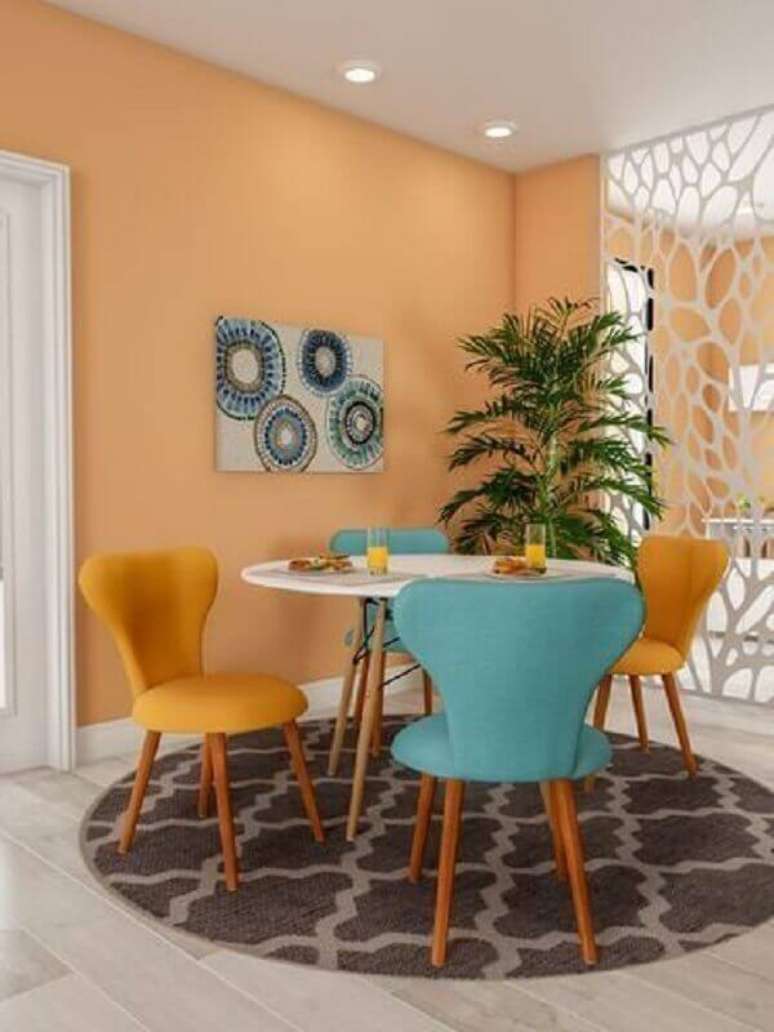 38. Decoração de sala de jantar com mesa pequena e cadeira azul e amarela – Foto: Arkpad