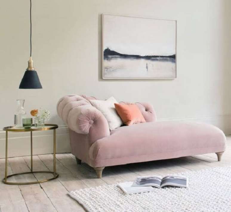 55. A mesa lateral posicionada ao lado do poltrona divã chaise rosa serve de apoio para objetos decorativos. Fonte: Ideal Home
