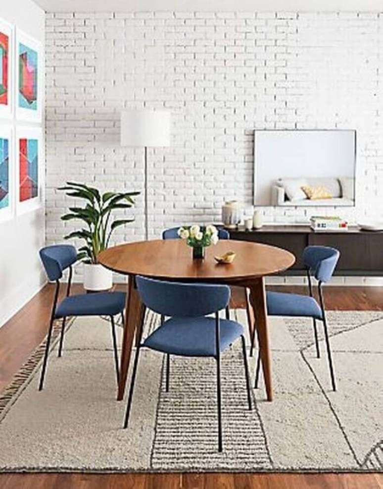 57. Sala de jantar decorada com parede de tijolinho branco e cadeira estofada azul – Foto: Room & Board