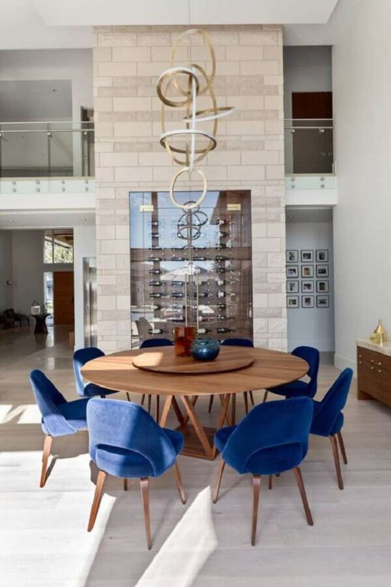 31. Cadeira estofada azul para sala de jantar moderna decorada com mesa redonda e adega planejada – Foto: House Of Bohn