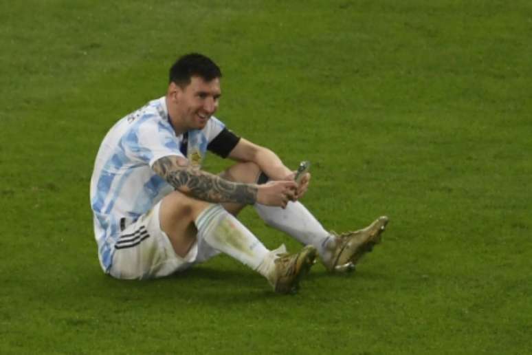 Após o jogo, Messi conversou com a família por chamada de vídeo ainda no gramado (Foto: MAURO PIMENTEL / AFP)