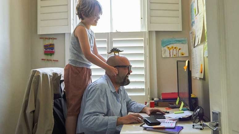 Homem trabalhando de casa com o filho