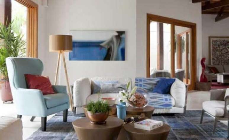 59. Sala decorada com poltrona azul pastel e abajur de p&eacute; alto de madeira &ndash; Foto: Deborah Roig