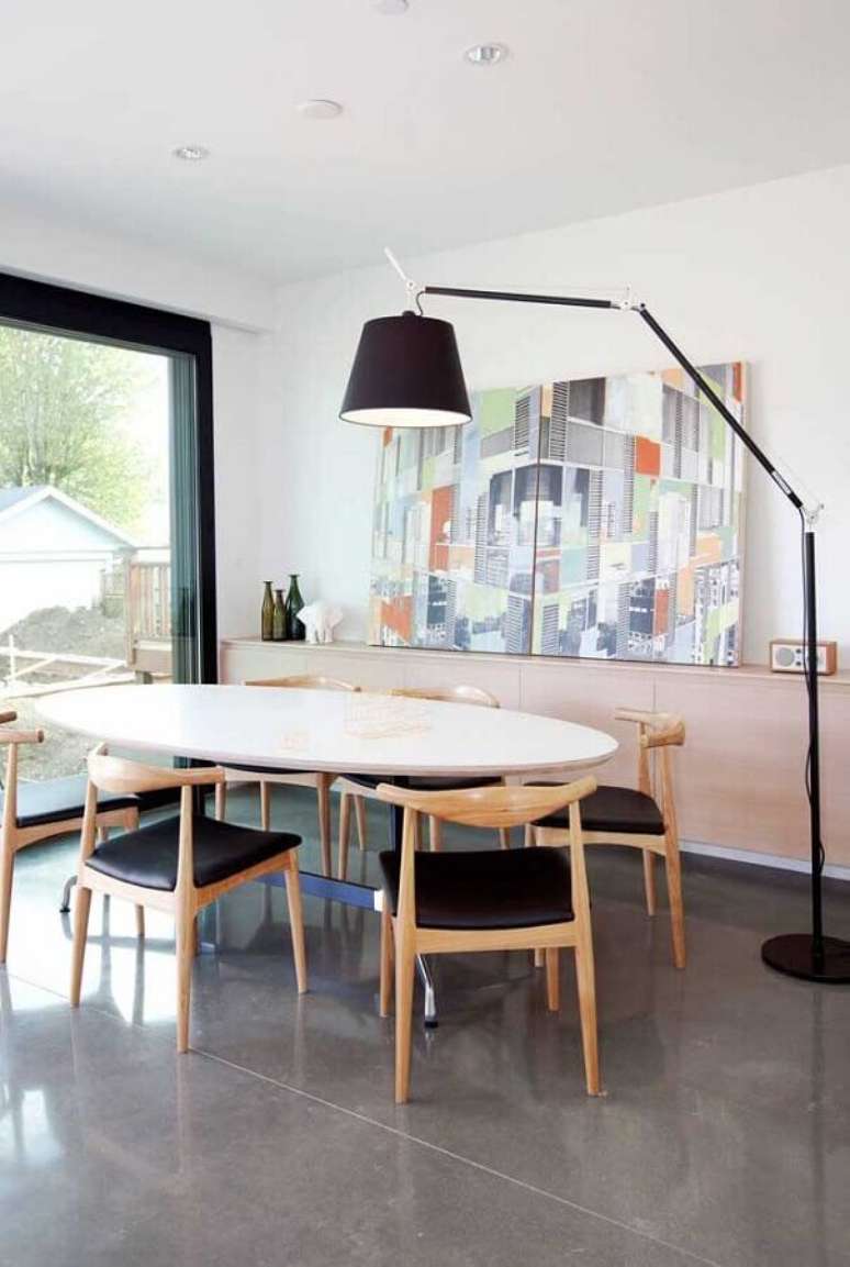 20. Abajur de p&eacute; para sala de jantar decorada com mesa oval e quadro grande &ndash; Foto: Futurist Architecture