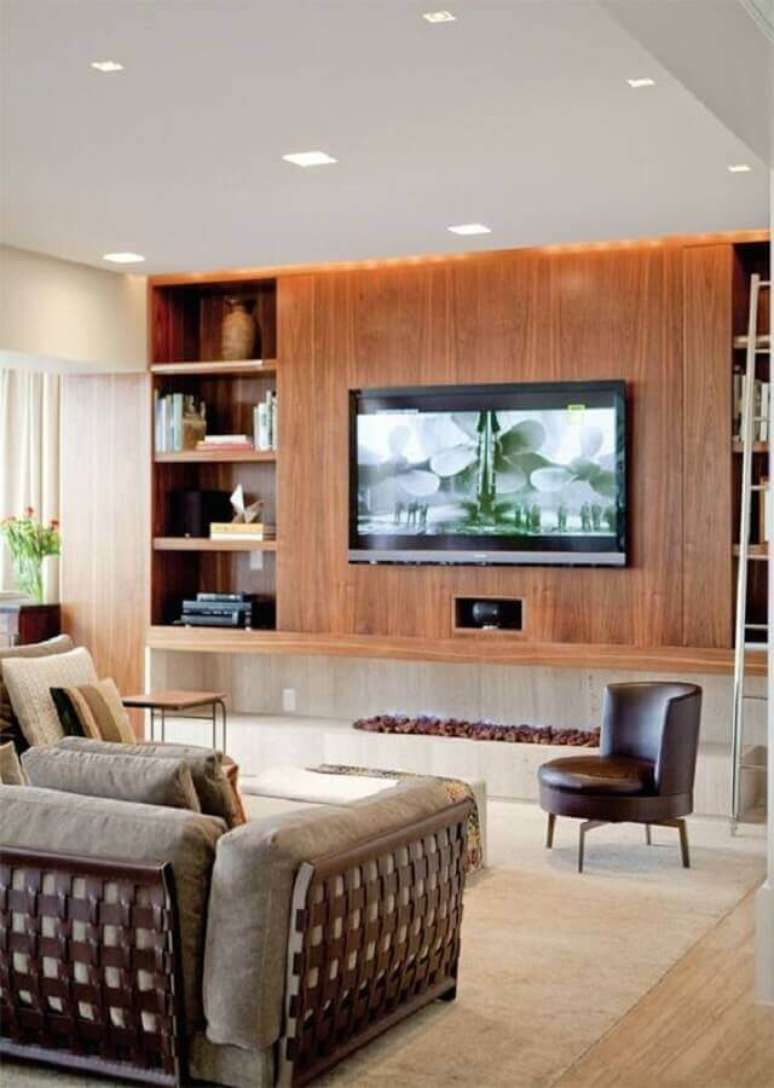 5. Decoração de sala com lareira ecológica grande e painel de madeira – Foto: Studio1202