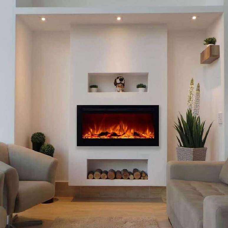 9. Decoração clean para sala com lareira elétrica e vasos de plantas – Foto: Pinterest