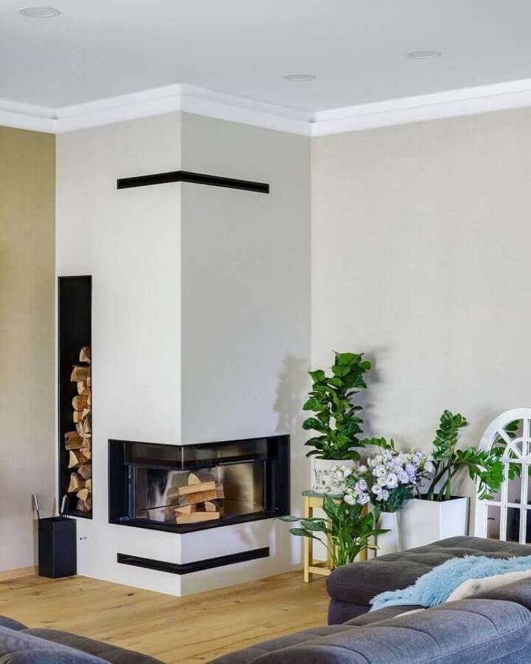 22. Decoração de sala com lareira de canto e nicho para armazenar lenha – Foto: Home Fashion Trend