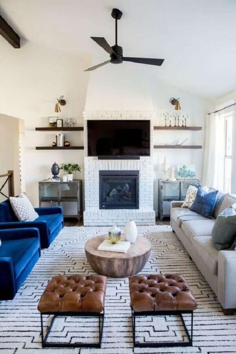 39. Poltrona azul para decoração de sala branca com lareira rústica – Foto: Arquitrecos