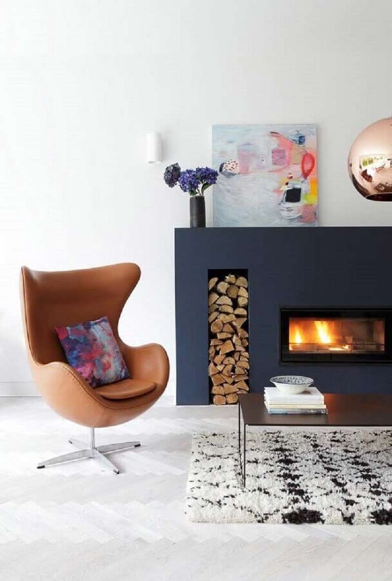 23. Sala com lareira decorada com poltrona de couro marrom – Foto: Houzz