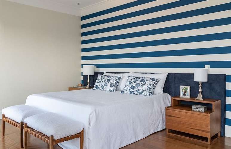 4. Decoração de quarto de casal com cabeceira colorida azul estofada e papel de parede listrado – Foto: habitissimo