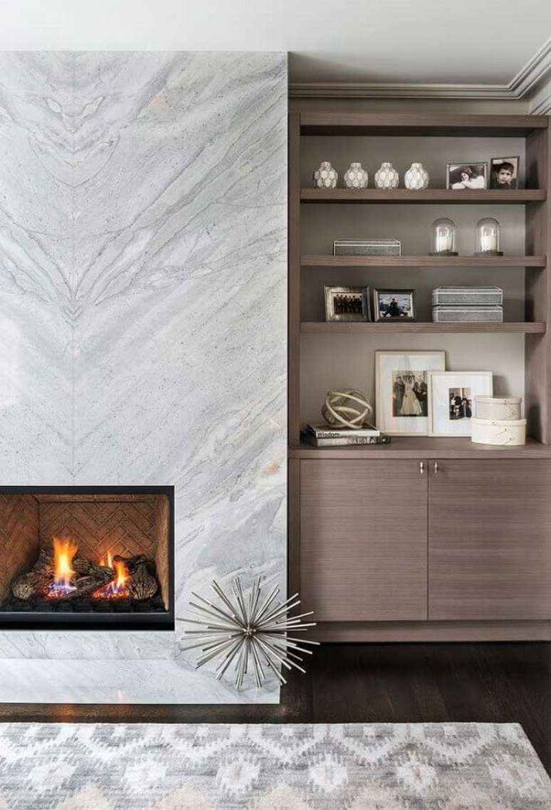 43. Revestimento de mármore para decoração sofisticada de sala com lareira – Foto: Jeito de Casa