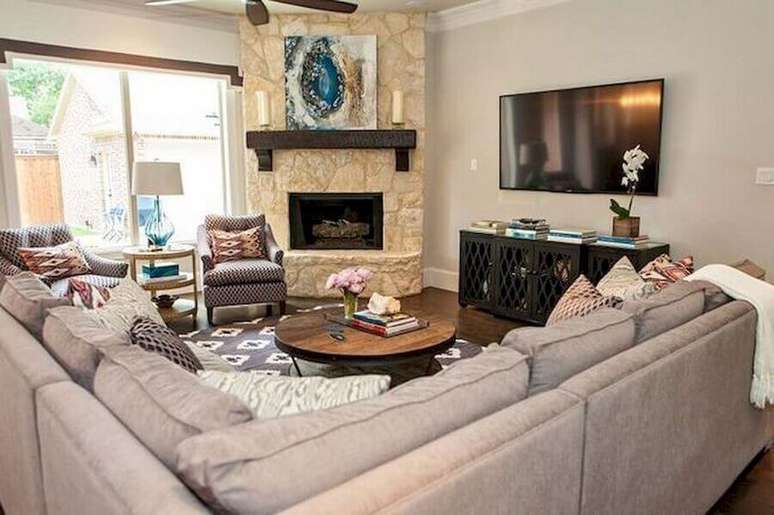 54. Sofá de canto para decoração de sala com lareira de canto rústica – Foto: Pinterest