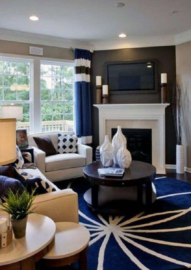 17. Decoração clássica para sala com lareira e tapete redondo azul e branco – Foto: Next Luxury