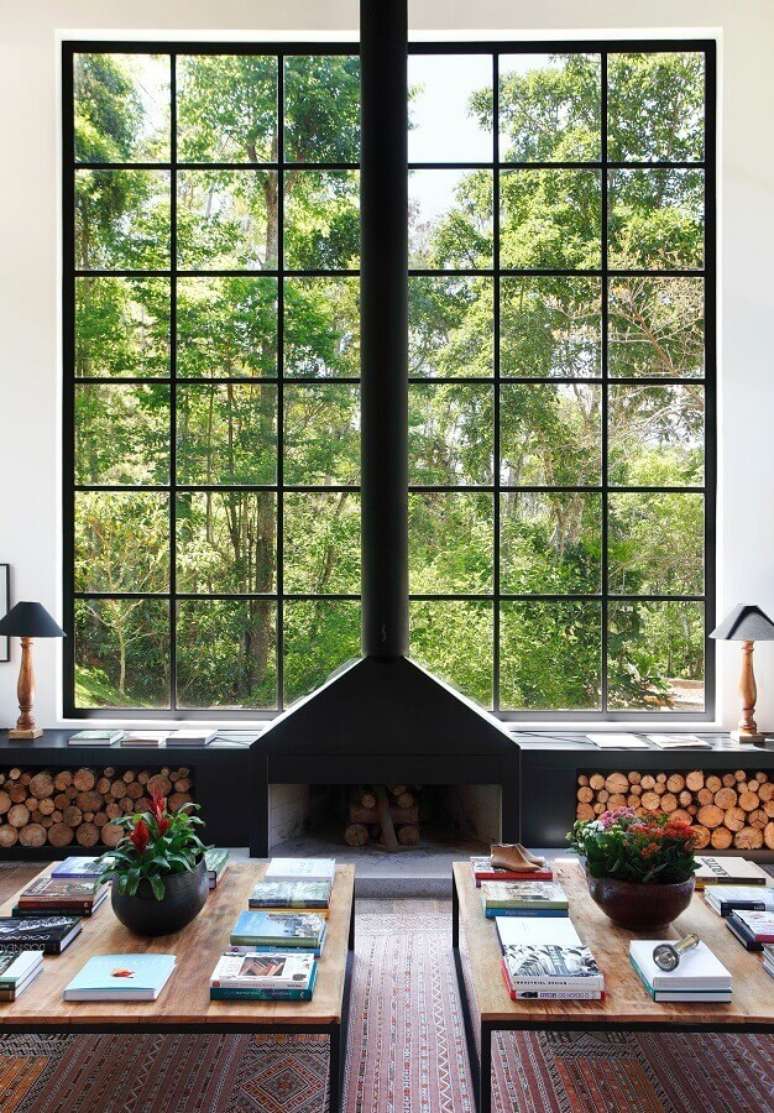 52. Sala de estar com lareira rústica decorada com amplas janelas – Foto: Home Fashion Trend