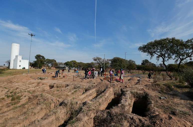 Parentes de mortos pela Covid-19 ao lado de novas valas abertas em cemit&eacute;rio de C&oacute;rdoba, na Argentina
11/07/2021 REUTERS/Agustin Marcarian