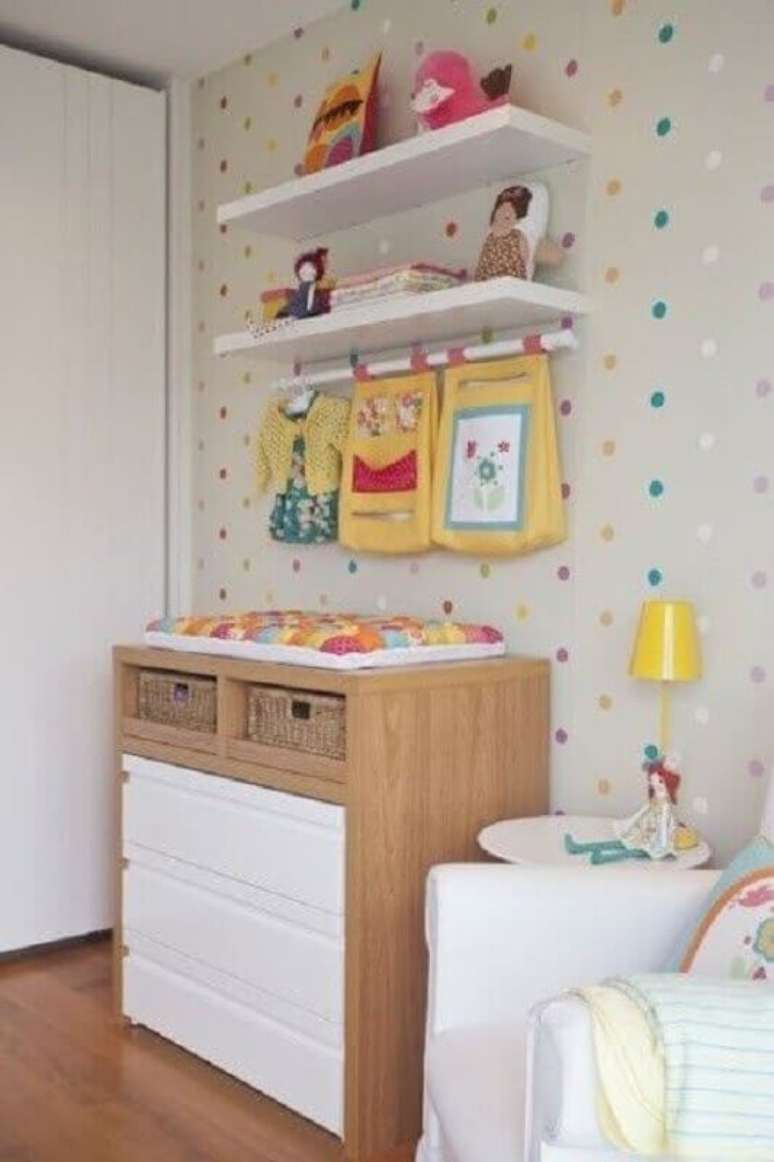 43. Cômoda com trocador de madeira para decoração de quarto de bebê com papel de parede de bolinhas coloridas – Foto: Pinterest