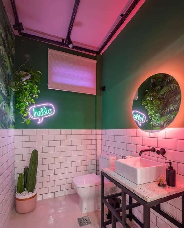 52. Banheiro com luz neon cor de rosa e luminaria com frase apontando para o cacto – Foto Liv Decora