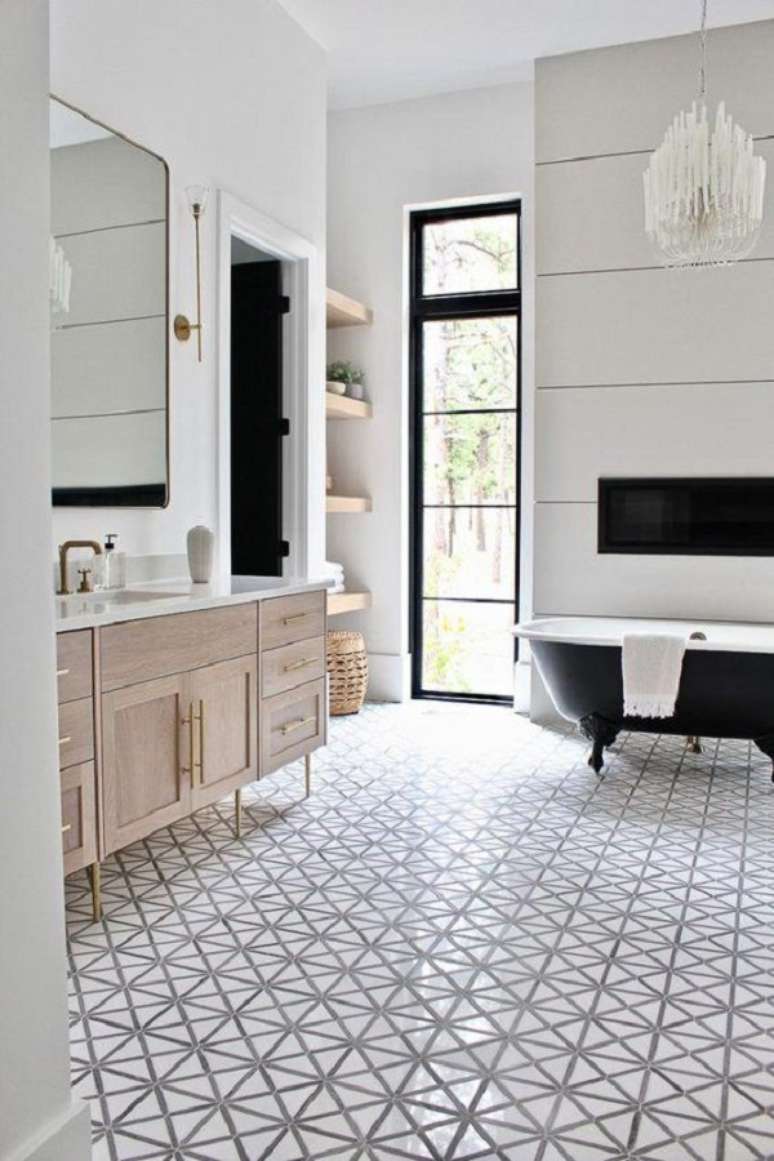 30. Decoração de banheiro grande com banheira preta vitoriana e gabinete de madeira – Foto: Apartment Therapy