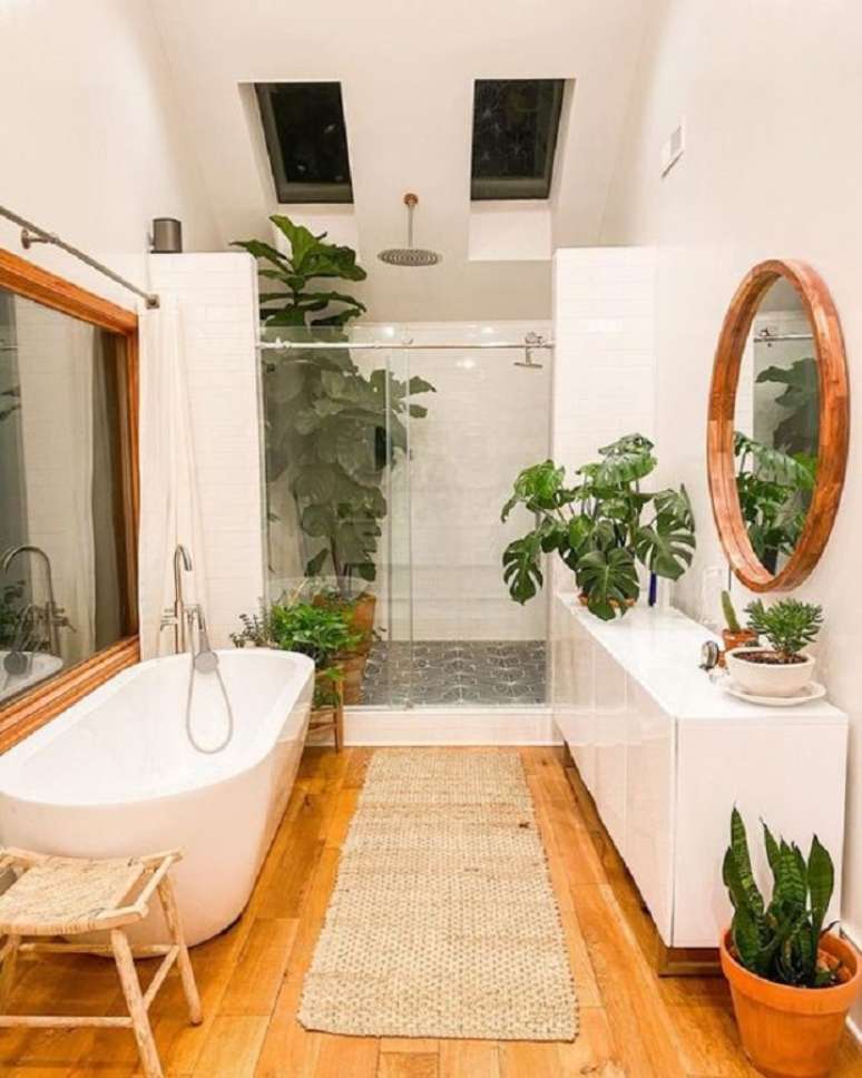 56. Modelo de banheiro grande rústico decorado com banheira de imersão e espelho redondo – Foto: Fashion Bubbles