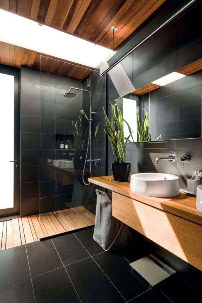 8. Os detalhes em madeira ajudam a deixar o banheiro grande moderno e preto mais aconchegante – Foto: Futurist Architecture