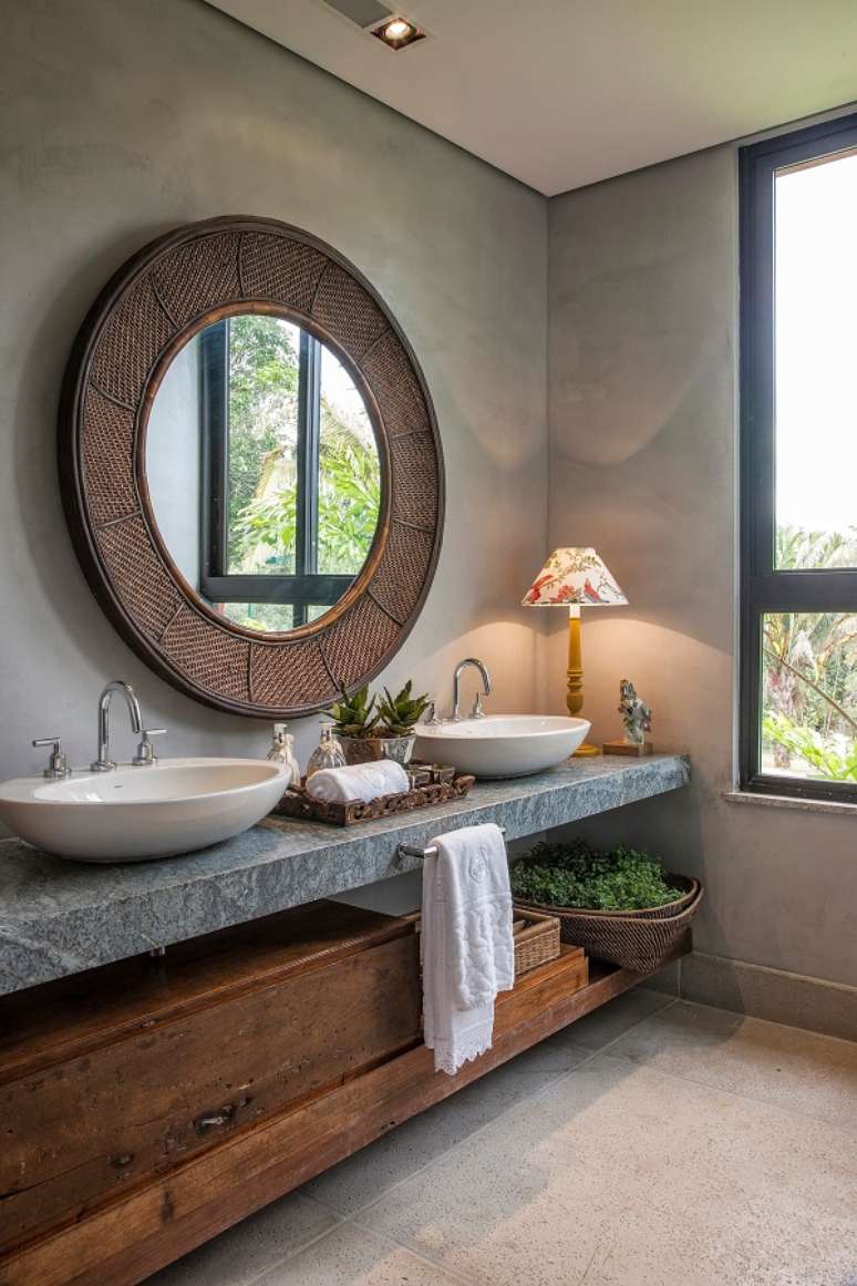 16. Banheiro grande decorado com parede de cimento queimado e espelho redondo rústico – Foto: Pinterest