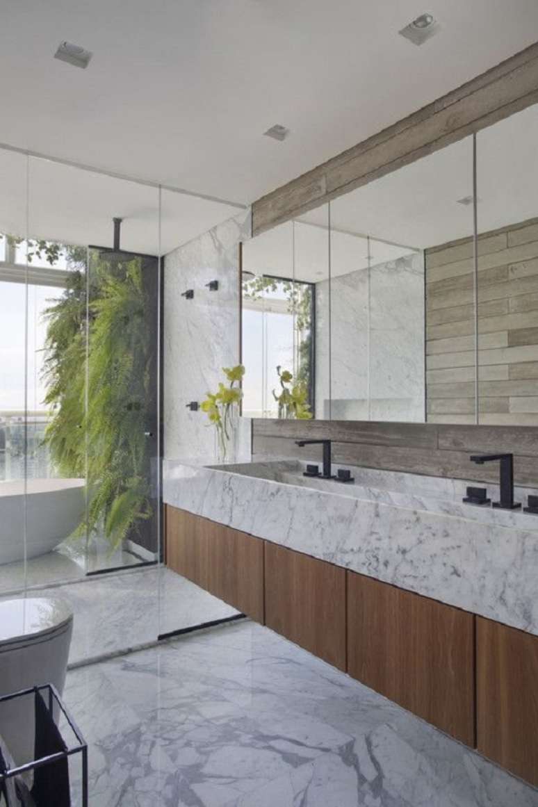 48. Gabinete de madeira com pia de mármore para decoração de banheiro grande – Foto: Archdaily