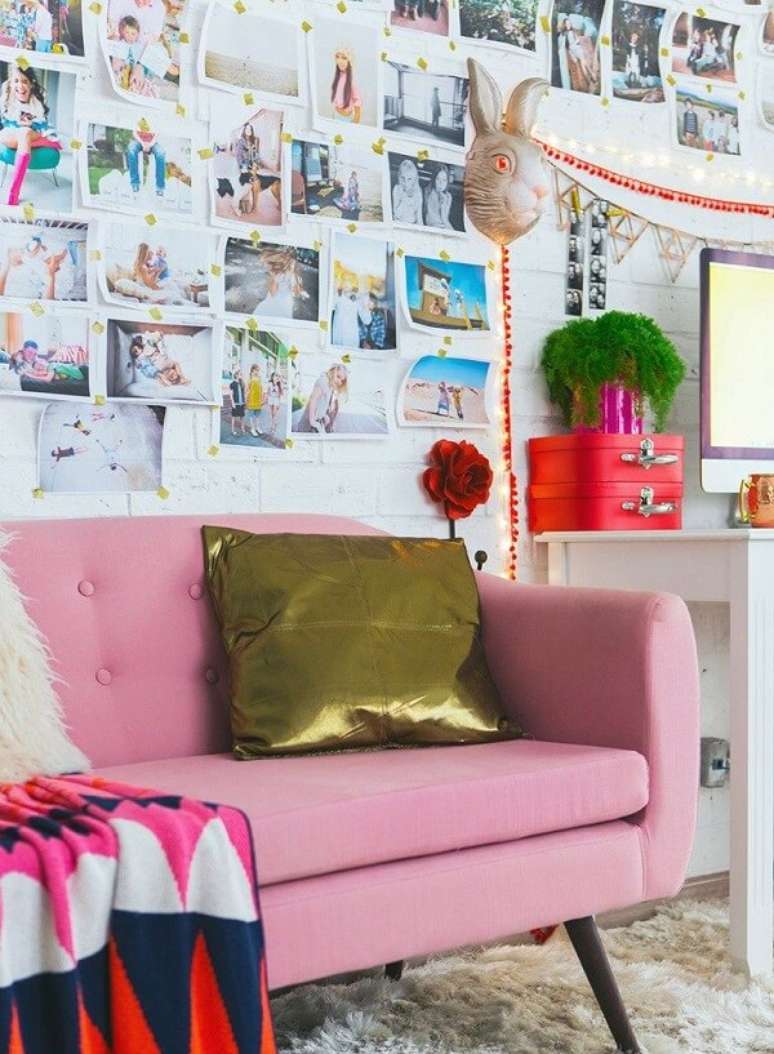 42. Decora&ccedil;&atilde;o colorida composta por sof&aacute; rosa, almofada dourada e painel de fotos na parede. Fonte: Pinterest