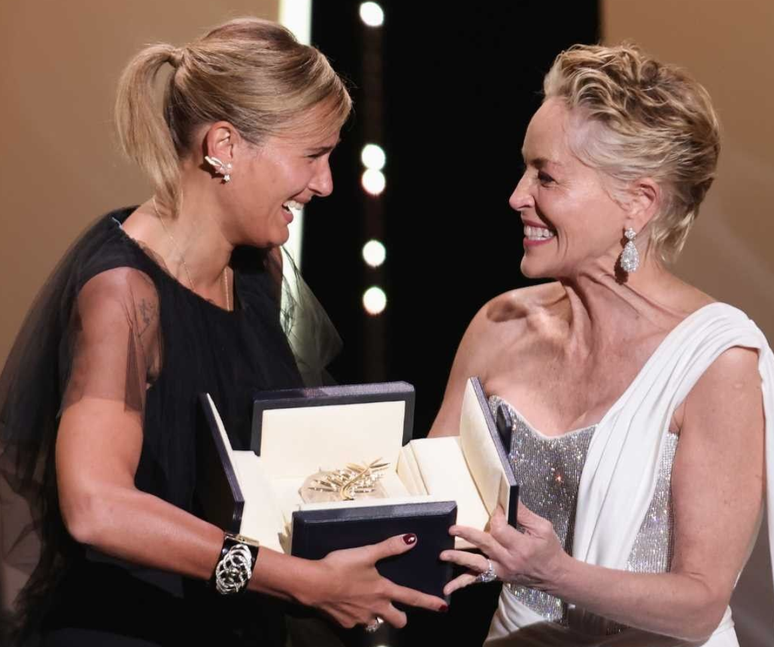 A diretora Julia Ducournau recebe a Palma de Ouro das mãos de Sharon Stone