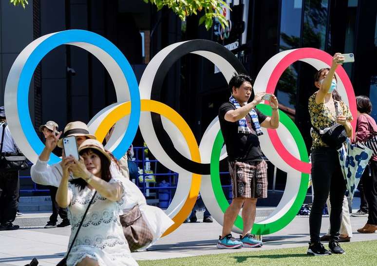 Pessoas tiram selfies em frente aos anéis olímpicos perto do Estádio Nacional em Tóquio
19/07/2021
REUTERS/Naoki Ogura