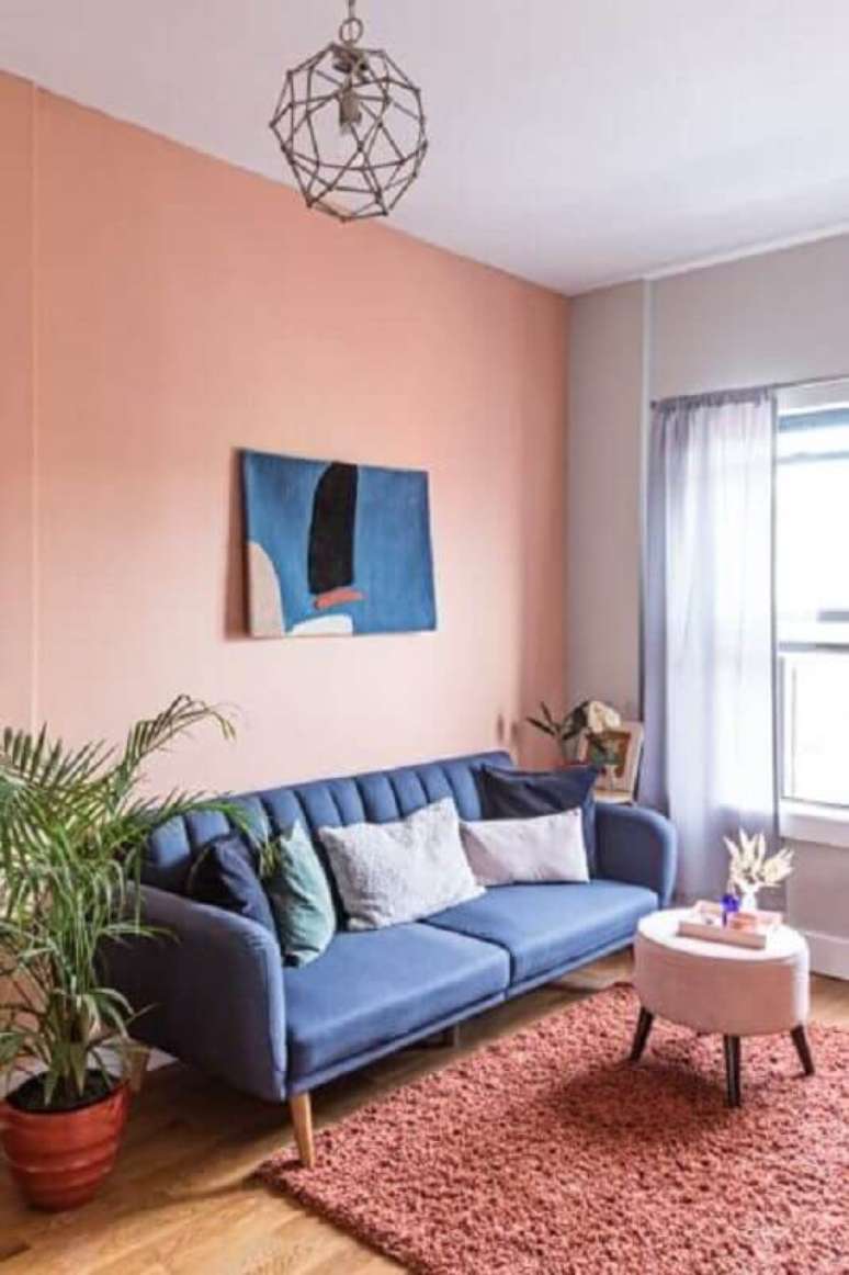 32. Decoração rosa chá para sala de estar com sofá azul – Foto: Domino
