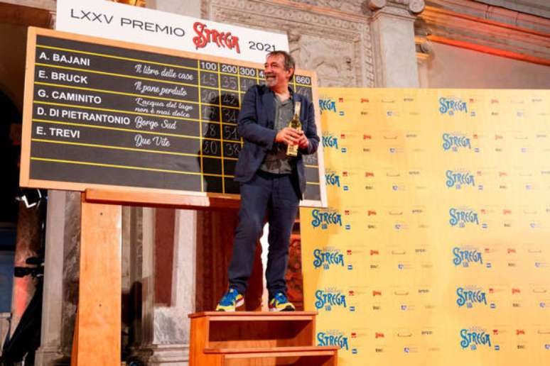 Emanuele Trevi posa em frente à tabela do Prêmio Strega 2021