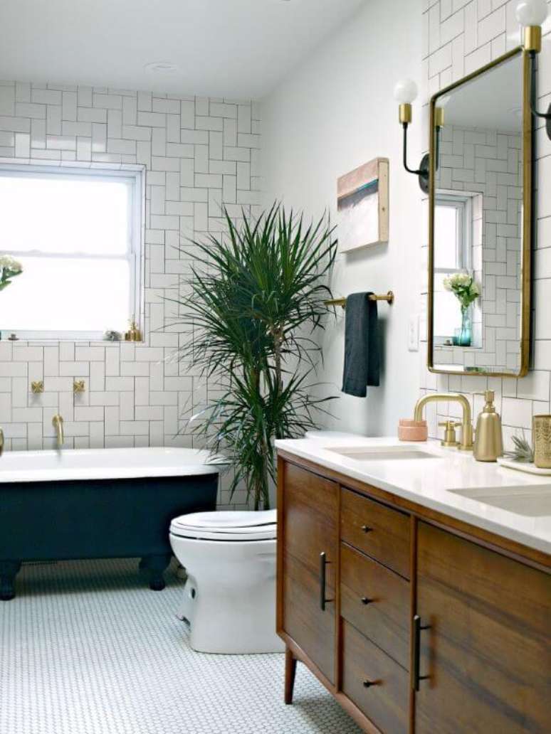 6. Banheiro moderno com banheira de p&eacute; e gabinete de madeira &ndash; Foto This Little Miggy