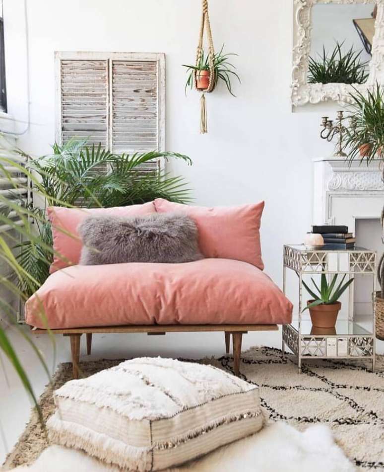 34. Decoração simples com sofá rosa chá de madeira e vasos de plantas – Foto: Pinterest