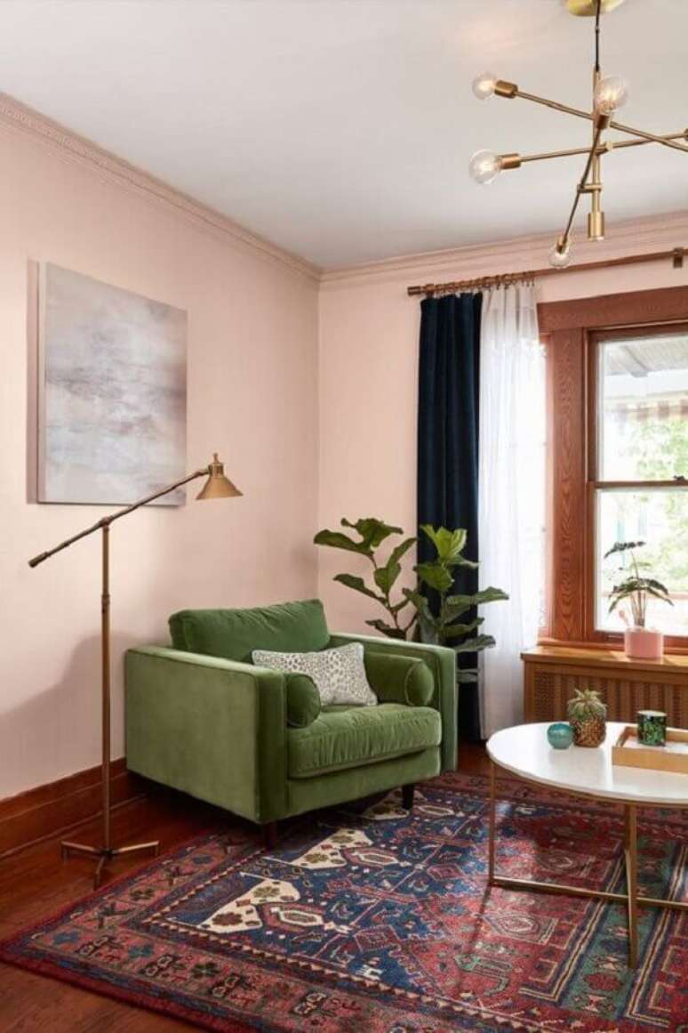 43. Parede rosa chá para decoração de sala com poltrona verde musgo – Foto: Histórias de Casa